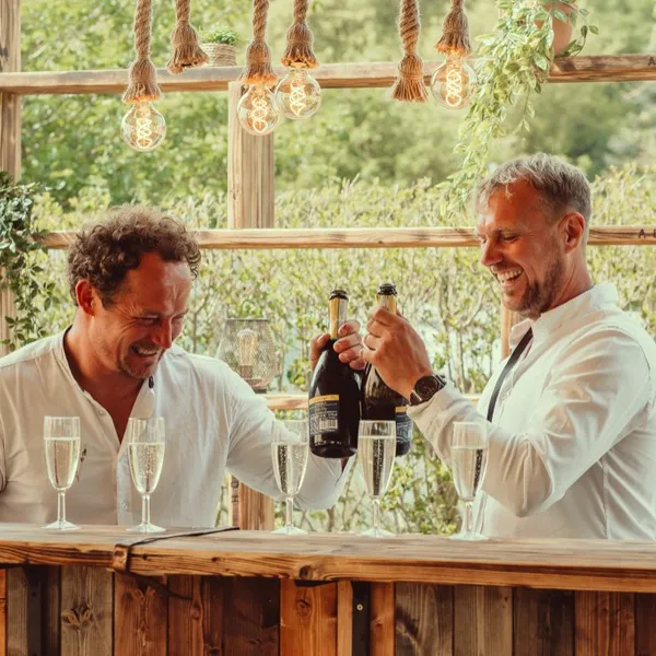 Guests toasting with champagne at the outdoor bar at Woodhill Weddings, Faversham, Kent
