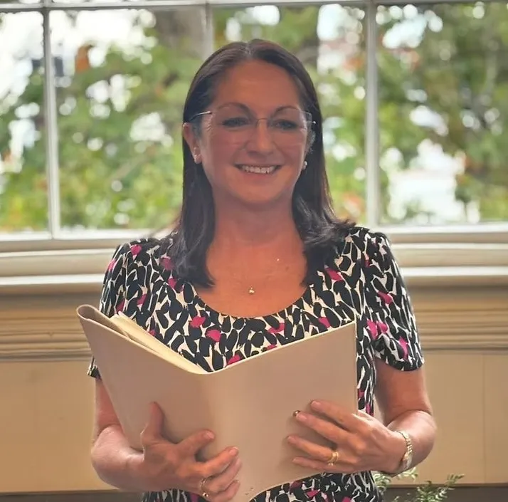 Alexa Young of Cherished Celebrant, holding a ceremony folder