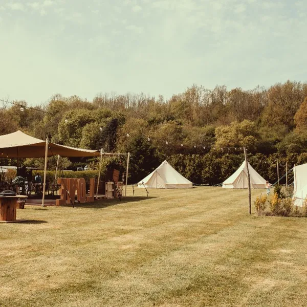 The grounds with the stretch tent, bell tents and LOVE letters at Woodhill Weddings, Faversham, Kent