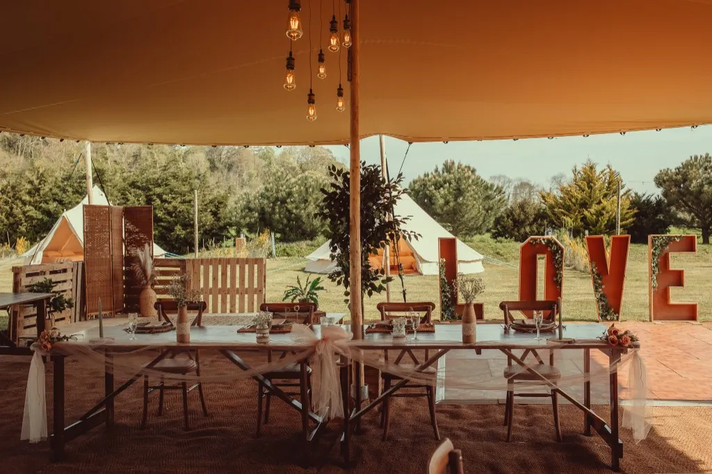 Wedding reception under the stretch tent with LOVE letters and countryside views at Woodhill Weddings, Faversham, Kent