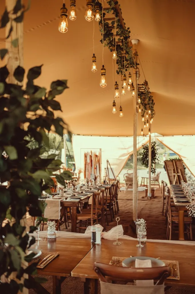 Dining tables set under the Bedouin stretch tent for a wedding reception at Woodhill Weddings, Faversham, Kent